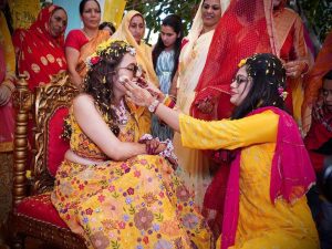 Bride enjoying haldi ceremony surrounded by smiling family members